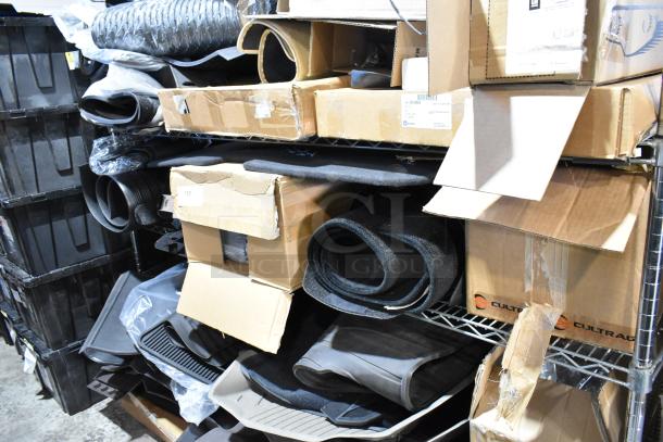 Tiered lot of various items, including car floor mats. Items in boxes and on shelves, mixed conditions.