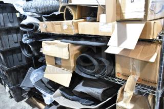 Tiered lot of various items, including car floor mats. Items in boxes and on shelves, mixed conditions.