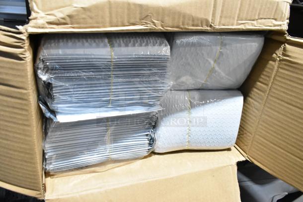 Open box containing a tiered lot of various items, including wrapped car floor mats. Items are neatly packaged.