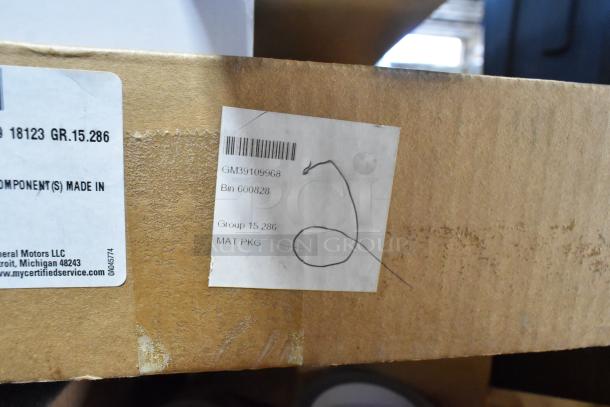 Cardboard box labeled "MAT PKG" from General Motors, showing barcode GM39109968. Box part of assorted item lot.