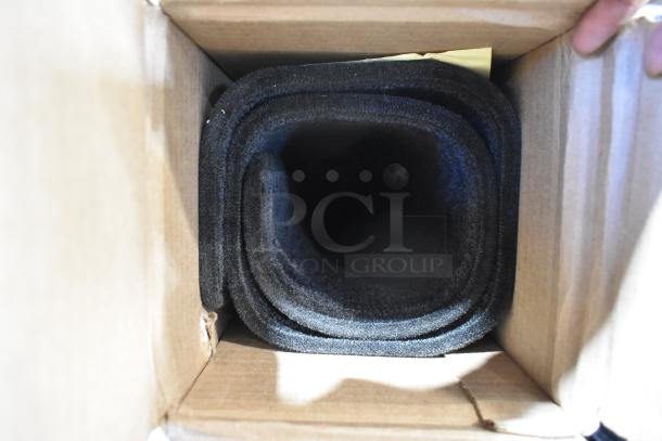 Box containing rolled black car floor mats, possibly new, cardboard packaging visible.