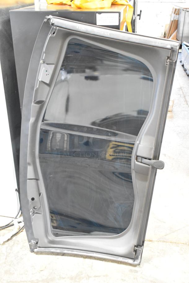 Car panel with clear glass, grey frame, and black handle. Slight wear visible on edges.