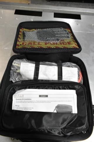 Cadillac roadside kit in black case, contains safety and emergency items. Includes installation instructions.
