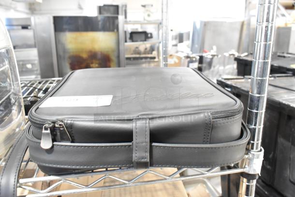 Black Cadillac kit case with embossed logo, zipper closure, and tag numbered 169. Appears in good condition.