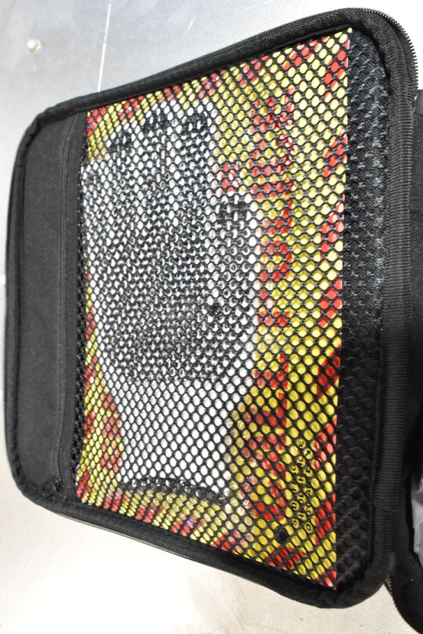 Cadillac Kit in a black case with a mesh front, containing various colorful graphic items, possibly promotional materials.