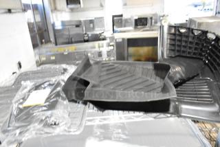 Three assorted items, including a black rubber car floor mat, in new condition, partially wrapped in clear plastic.