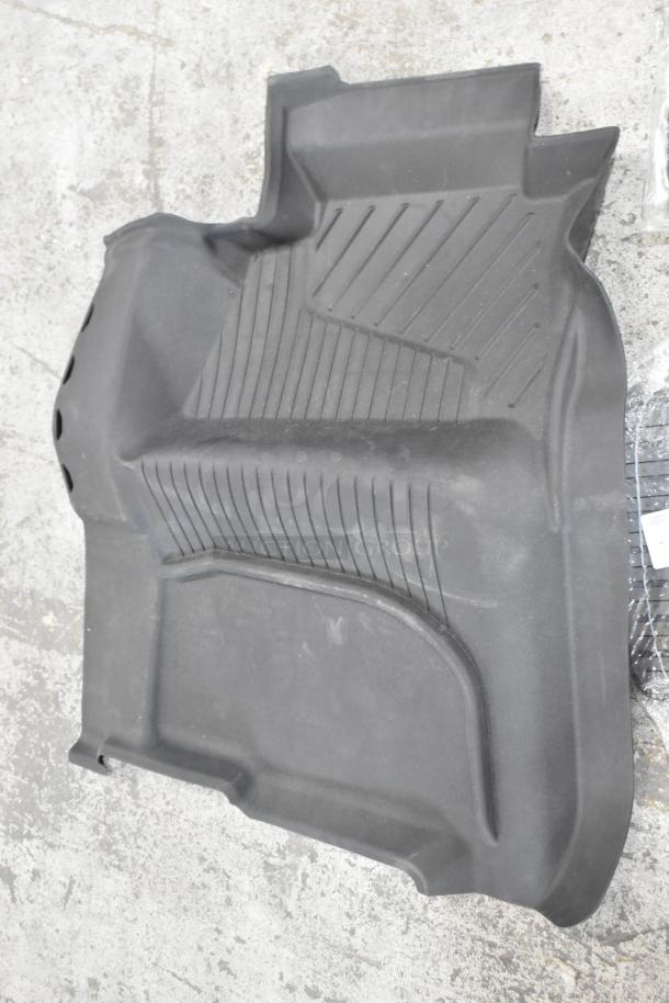 Black car floor mat with ribbed texture, in good condition, part of a set of three auction items.