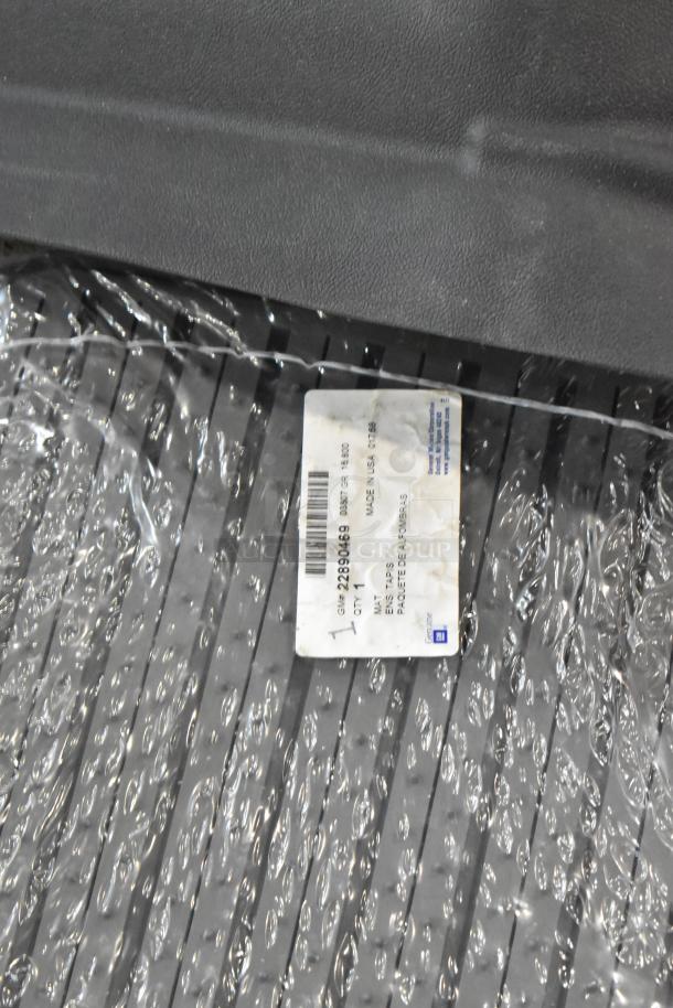 3 various items including a car floor mat in packaging with a GM label indicating model number 22890469; new condition.