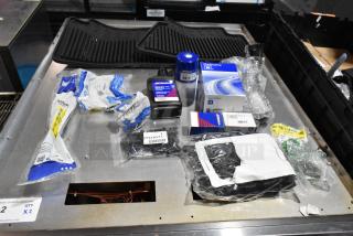 Lot including ACDelco Versatrak fluid and floor mats in black poly bin. Various automotive items, new condition with labels.