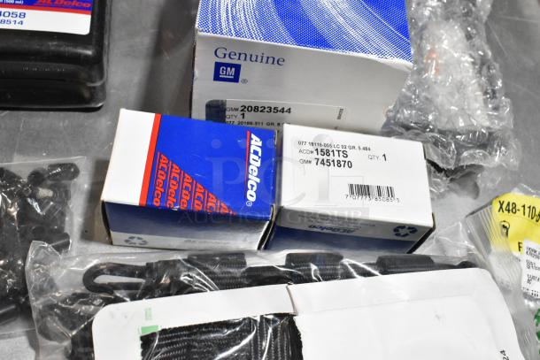 Lot of various items, including ACDelco Versatrak Fluid, GM Genuine Parts, floor mats in a black poly bin.