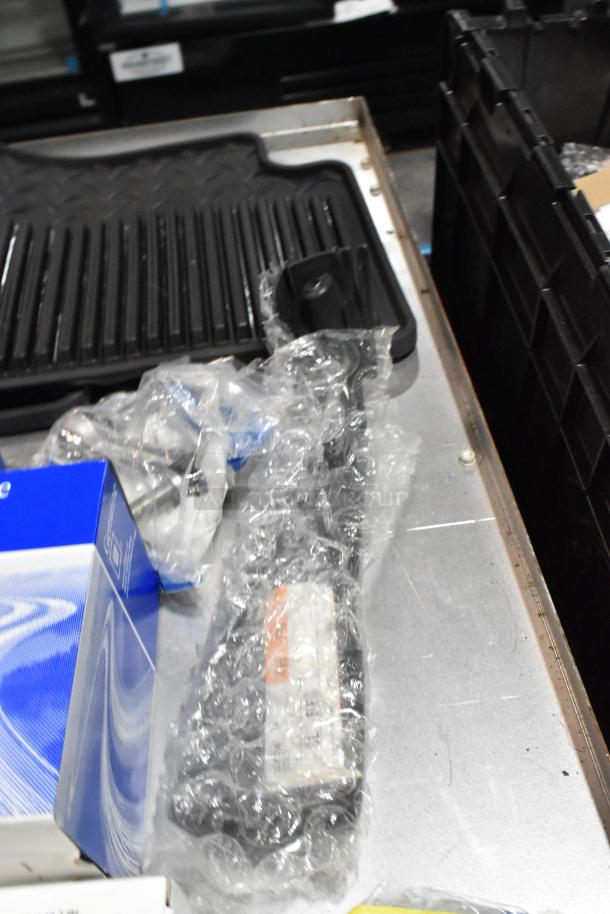 Lot including ACDelco Versatrak fluid and black floor mats in a poly bin. Items are wrapped, condition appears unused.