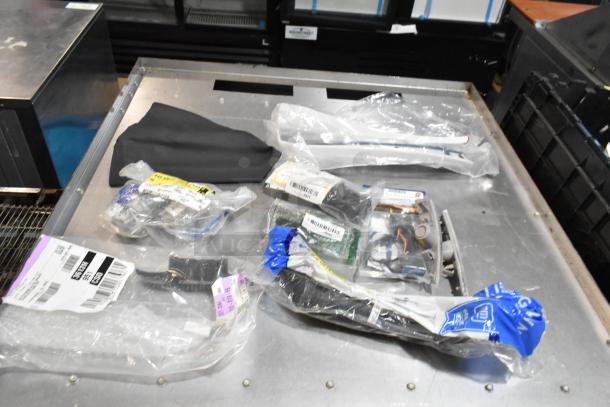 Lot of various items including ACDelco Ultraguard oil fluid, packaged in a black poly bin on a metal surface.