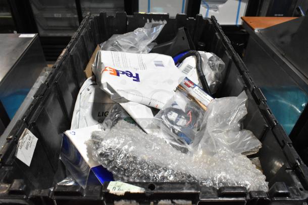 Lot of miscellaneous items in a black poly bin, includes ACDelco Ultraguard Oil Fluid, assorted packaging, and bubble wrap.