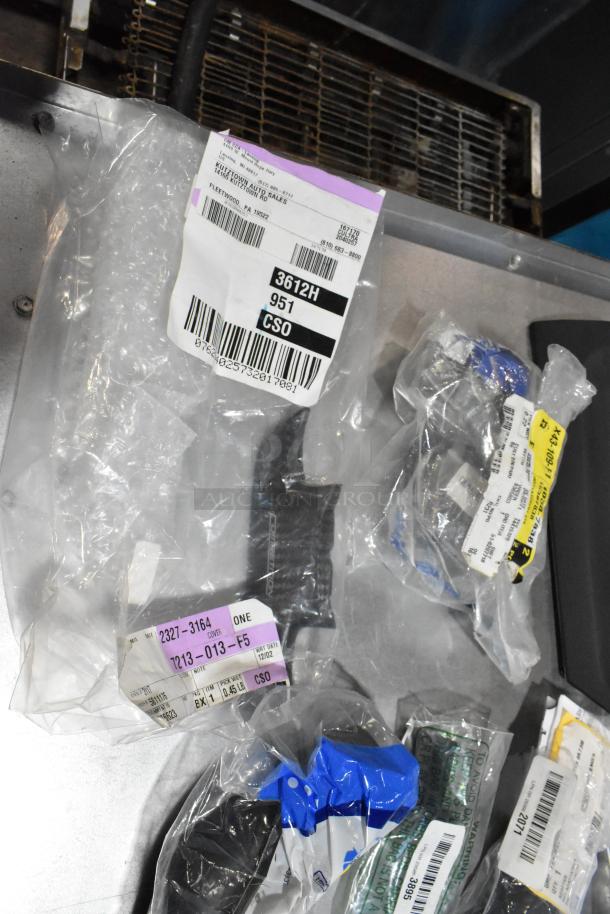 Lot of various automotive items in clear bags with labels. Includes ACDelco Ultraguard oil fluid, all in black poly bin.