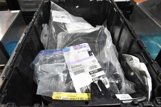 Lot of items in black poly bin, including a cargo net. Various packaging and labels visible, indicating item details.