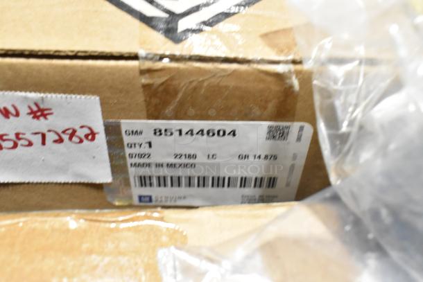Box with label marked GM# 85144604, quantity 1, made in Mexico, in a lot of various items including a cargo net in a black bin.