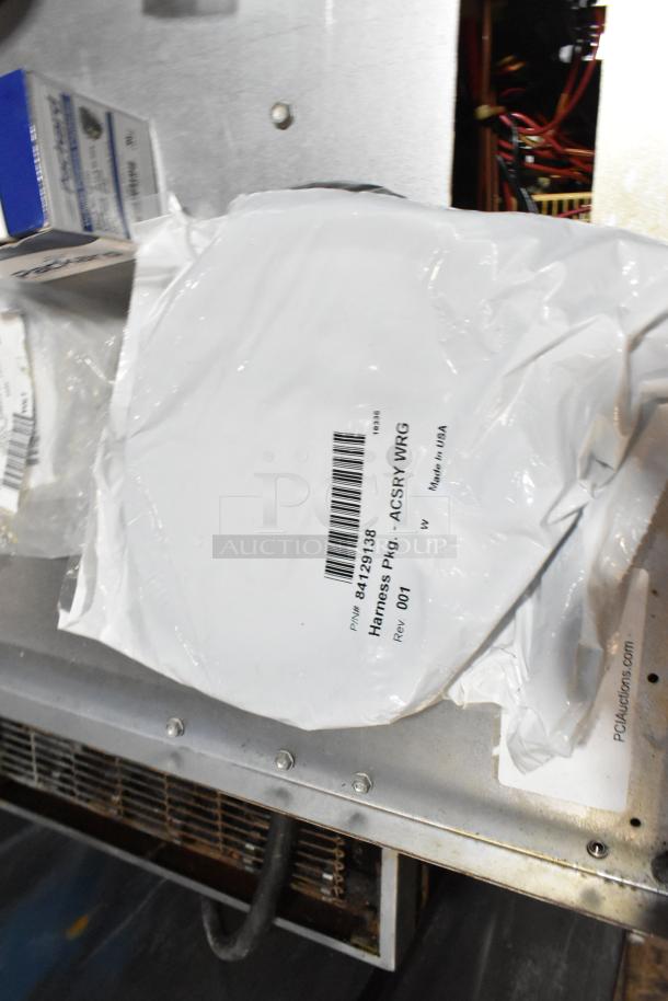 A collection of various items in a black poly bin, including a cargo net and items with barcode labels.