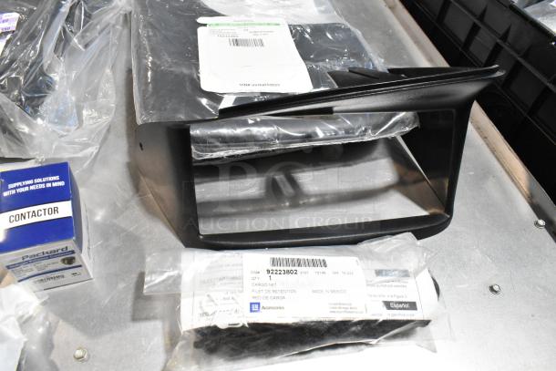 Lot of various items including a cargo net in a black poly bin. Visible tags show item details and GM branding.