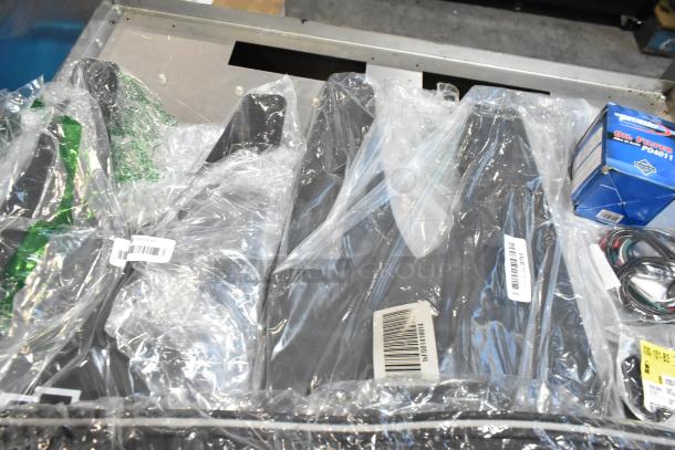 Lot of various items including mats and oil filter in black poly bin, new in packaging, oil filter model P04011 visible.