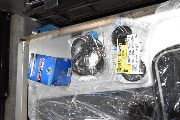 Lot of items including mats, wiring, and oil filter in a black poly bin. Oil filter box is branded "Promotive" P04011.