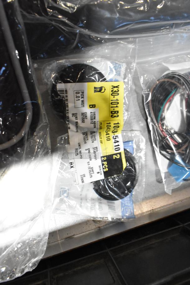 Assorted lot of items in a black poly bin; includes mats, wiring, and an oil filter. Visible label: part number X30-101-B3 103-5410.
