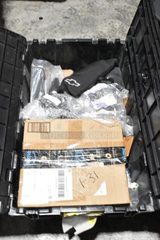 Lot of various items including GM wheel locks, stick shift, and packages in black poly bin. Contains visible Chevrolet logo.
