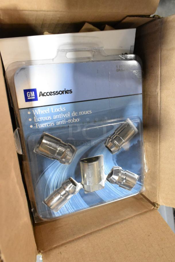 GM Accessories wheel locks pack in original box; part of a mixed items auction lot with black poly bin.