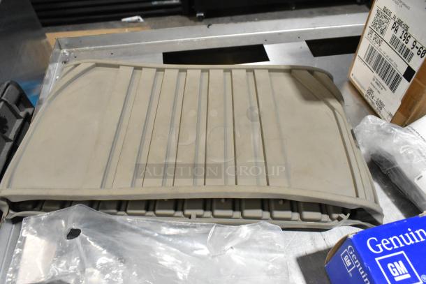 Lot of various items including a gray floor mat, in black poly bin. Includes a GM-branded box. Items appear gently used.