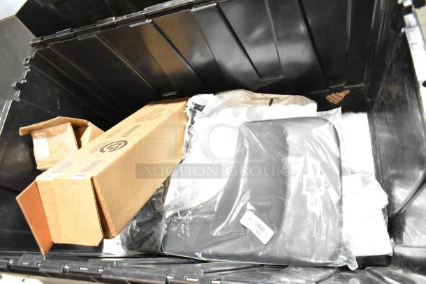 Lot of various items including floor mats in a black poly bin. Includes cardboard boxes and items with visible labels.