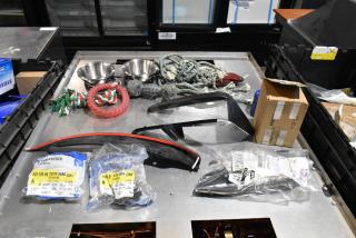 Lot of various items including dog toys in a black poly bin, featuring rope toys, bowls, and sealed items with labels.