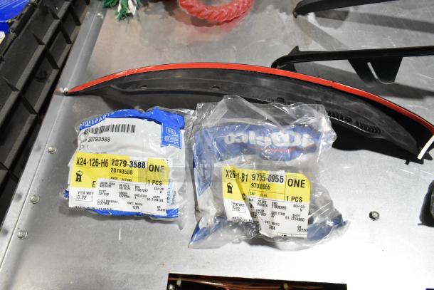 Lot of various items in a black poly bin, including packaged automotive parts with labels visible, and assorted dog toys.