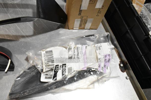 Lot of various items in a black poly bin, including dog toys. Items are in a plastic bag with visible labels and barcodes.