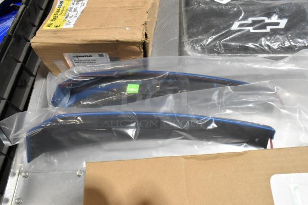 Lot of items in black poly bin, featuring 22935639 mud flaps, packed in clear plastic. Includes box with part label, GM 84453446.