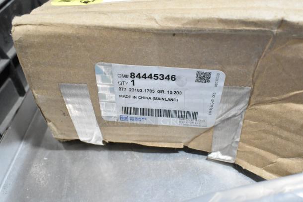 Cardboard box with GM#84445346 label, "Made in China," includes genuine parts. Part of auction lot with black poly bin and mud flaps.