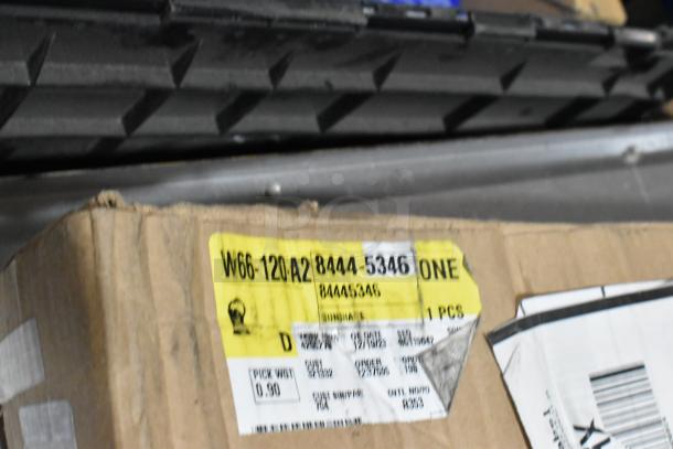 Lot of various items including 22935639 mud flaps in a black poly bin. Visible label with code W66-120-A2 and order details.