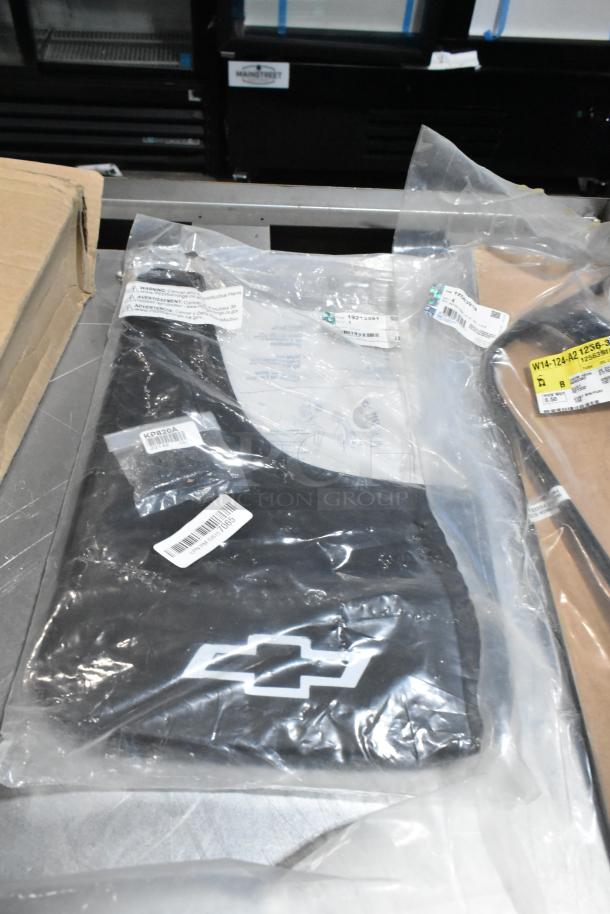 Lot with various items including Chevrolet logo mud flaps in sealed packaging, visible barcodes, in black poly bin.