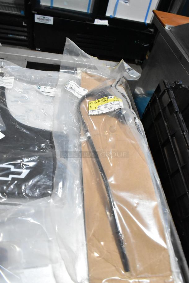 Lot of miscellaneous items, including 22935639 mud flaps, sealed in a black poly bin. Various items visible, some with labels.