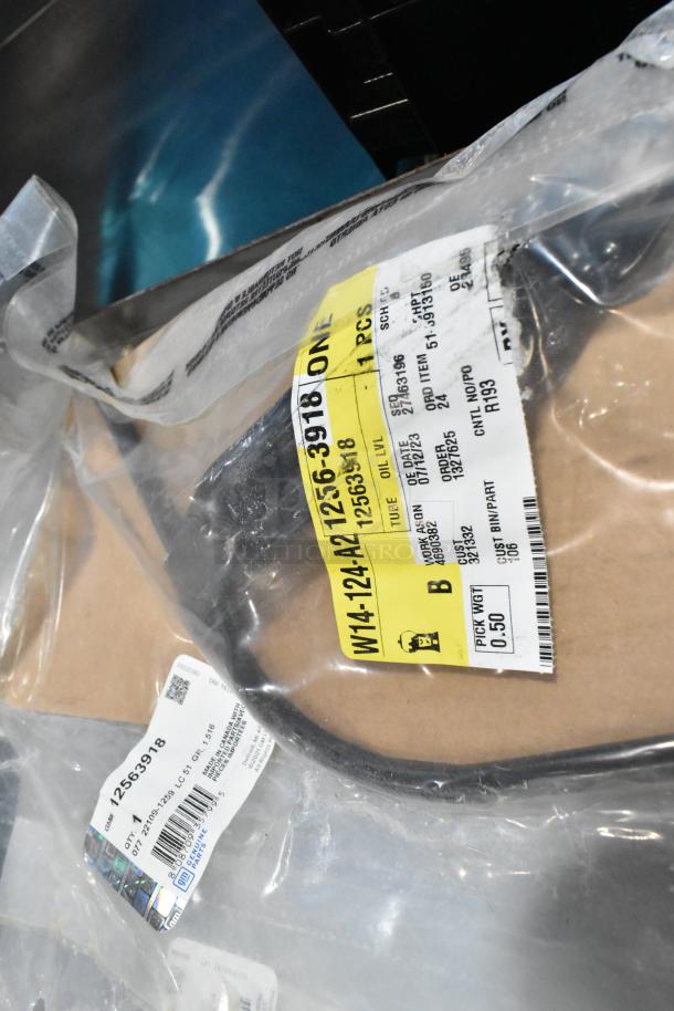 Various items in a black poly bin, including GM 22935639 mud flaps. Tags show part numbers and packaging details.