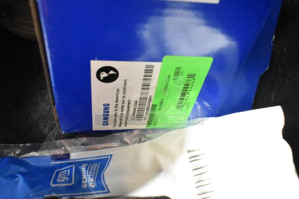 Lot of various items including Samsung C504S ink cartridges in black poly bin. Visible labels show model CLT-K505/ XAA, for sale in Americas only.