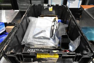 Black poly bin with various items including an air filter and license plate frame. Items appear mixed, condition unknown.