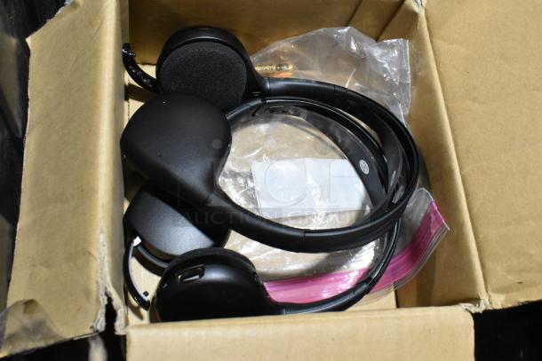 Lot of various items including black headphones, clear plastic bags, and packaging in a cardboard box.