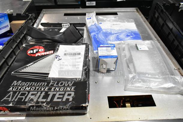 Lot of items including aFe Power Magnum Flow air filter, AC Delco filter, license plate frame in black poly bin.