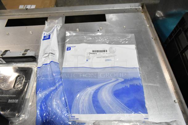 Lot of various items including a GM genuine air filter and Baron license plate frame in a black poly bin.