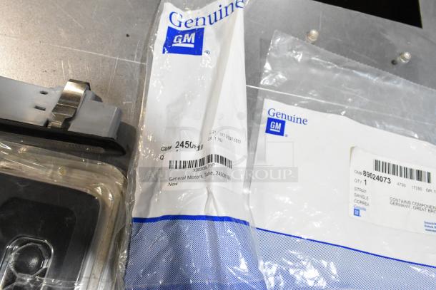 Lot of various items including a GM air filter and license plate frame, packaged with Genuine GM labels, in black poly bin.