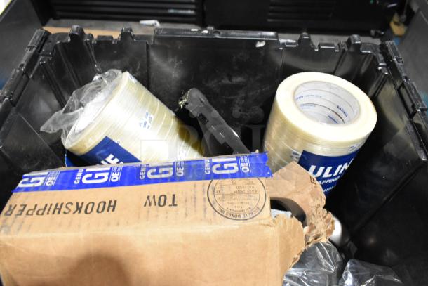 Lot of various items including tape and cardboard box in black poly bin, visible labels include "HOOKSHIPPER" and "ULINE".