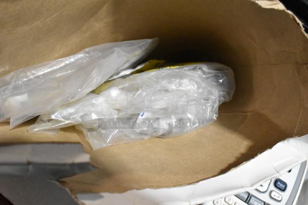 Inside a brown paper bag with plastic-wrapped items, including a glimpse of a Brother label printer keypad.