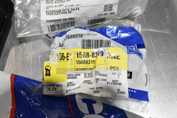 Lot of items including labeled auto parts packaging. Labels show parts numbers and shipping information.