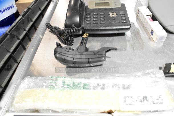 Lot of various items including a corded telephone, thermometer in packaging, all in a black poly bin.