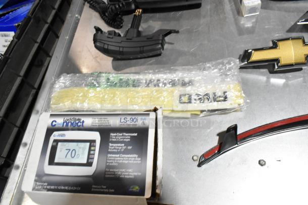 Lot including a corded telephone and a LockState Connect LS-90i thermostat in a black poly bin. Items in used condition.