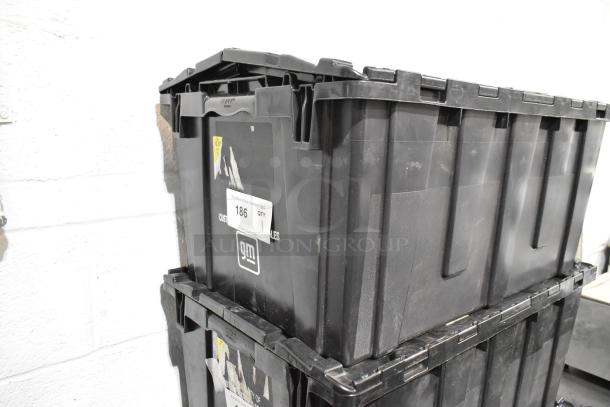 Black poly bin containing a lot of assorted items, including floor mats and headphones. Visible label indicates "Lot 186".